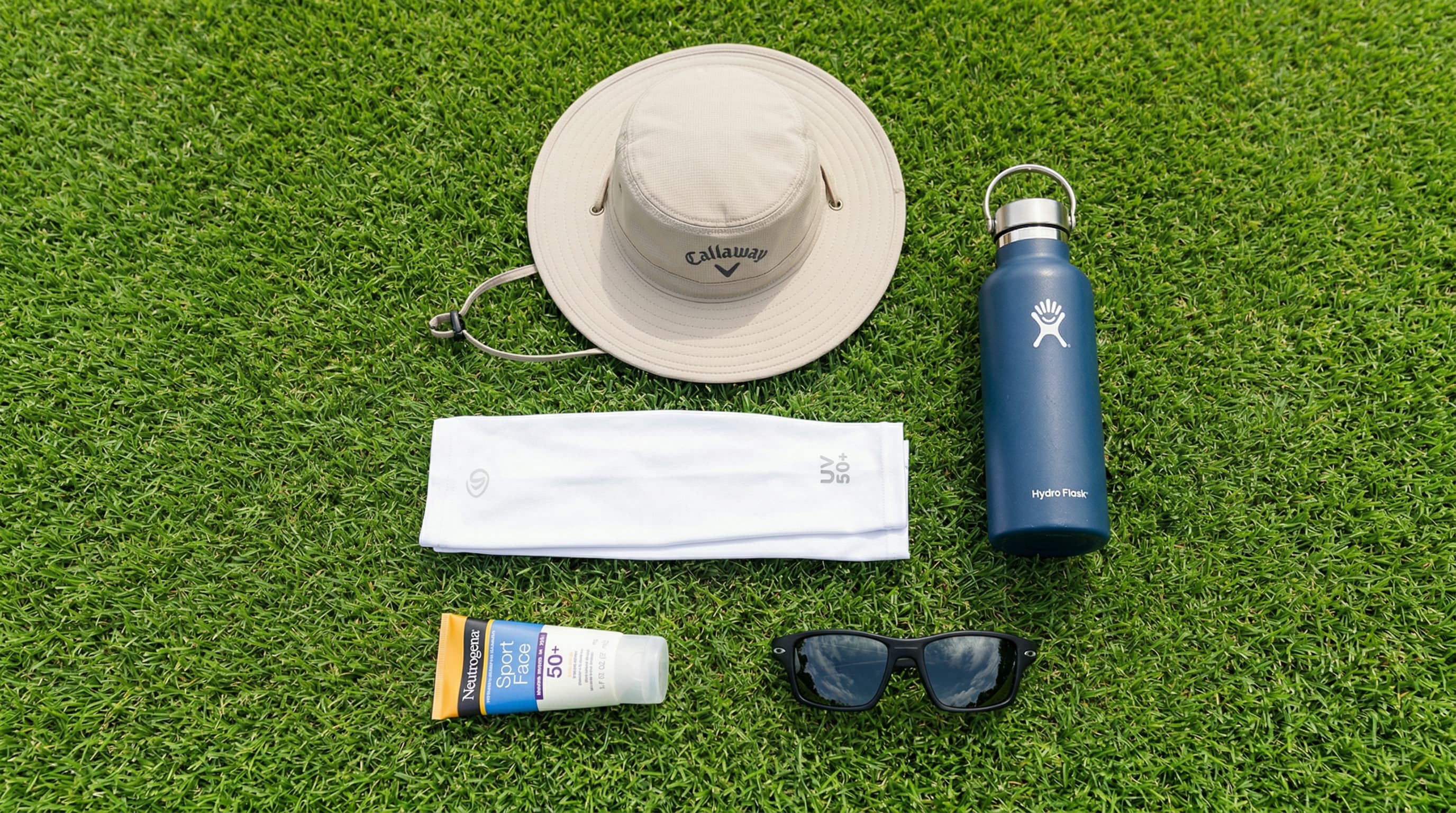 Essential golf sun protection kit: wide-brim hat, SPF 50 sunscreen, UV arm sleeves, polarized sunglasses, water bottle